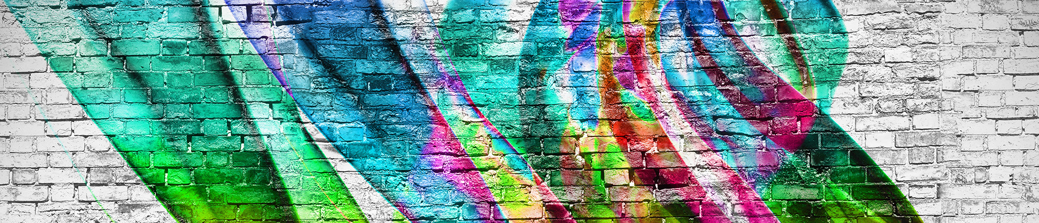 Colorful graffiti against a black and white brick wall